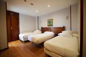 Habitación de hotel con 2 camas y sofá en Hotel Villalegre, en Avilés