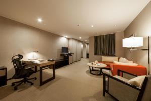 新竹市的住宿－迎曦大飯店，客厅配有沙发和书桌。