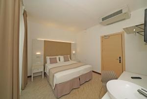 a hotel room with a bed and a sink at Hotel Strand a frontemare in Lido di Jesolo