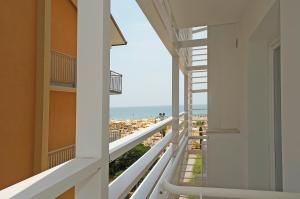 リド・ディ・イエゾロにあるHotel Strand a frontemareのビーチハウスのバルコニーからビーチの景色を望めます。