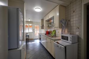 eine Küche mit weißen Schränken und einer weißen Mikrowelle in der Unterkunft Ferienwohnung in Wasen
