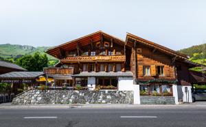 a wooden building on the side of a street at Hotel Restaurant Les Lilas in Les Diablerets