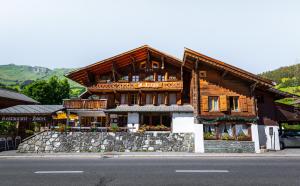 ein Holzgebäude an der Straßenseite in der Unterkunft Hotel Restaurant Les Lilas in Les Diablerets