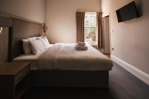 a hotel room with a bed with a teddy bear on it at St Andrews Town Hotel in Droitwich