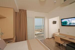 una camera con letto e vista sull'oceano di Hotel Strand a frontemare a Lido di Jesolo