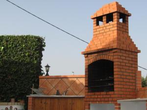 una chimenea de ladrillo con horno frente a un edificio en Good Feeling Hostel & Guest House, en Raposeira