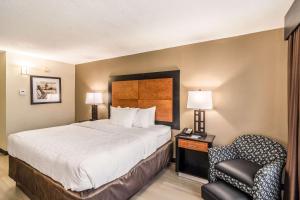 Habitación de hotel con cama y silla en Quality Inn, en Pensacola