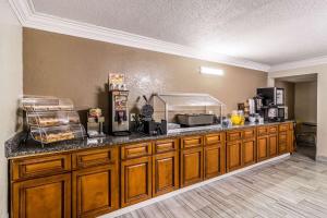 a kitchen with wooden cabinets and a counter top at Quality Inn in Pensacola