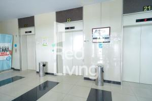 een lobby met twee deuren en een bord op de muur bij RedLiving Apartemen Green Pramuka - Aokla Property Tower Orchid in Jakarta