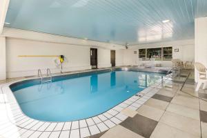 a large pool with blue water in a building at Sleep Inn Airport in Sioux Falls