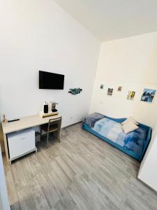 una camera con letto, scrivania e TV di B&B BenInCasa a Vietri