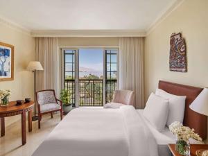 een hotelkamer met een bed en een balkon bij Mövenpick Resort & Residences Aqaba in Aqaba