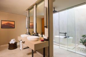 a bathroom with two sinks and a tub at Alila Hinu Bay Salalah Mirbat in Salalah