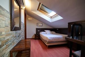 a hotel room with a bed and a skylight at Hotel Villalegre in Avilés