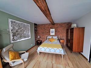 sypialnia z łóżkiem i ceglaną ścianą w obiekcie La Loggia - chambres d'hôtes w mieście Rieux