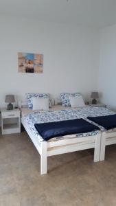 a white bed in a room with two tables at Apartmani Milosevic in Herceg-Novi