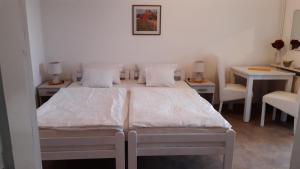 a bedroom with two beds and two tables and chairs at Apartmani Milosevic in Herceg-Novi