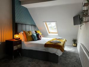 a bedroom with a bed with colorful pillows and a window at Woodquay House in Galway