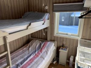 a small bedroom with two bunk beds and a window at Topp moderne familiehytte på Beitostølen (bygget i 2019) in Beitostøl