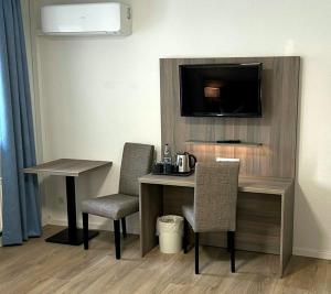 a hotel room with a desk with chairs and a television at Hotel Villa am Paradies in Jena +6 photos