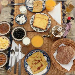 a table topped with plates of food and drinks at Auberge la Palmeraie in Mhamid