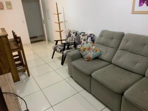 sala de estar con sofá y 2 sillas en Condomínio residencial mar azul, en Imbituba