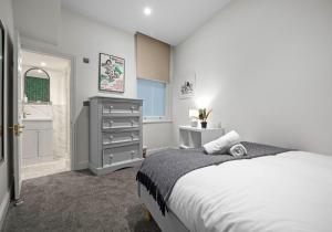 a bedroom with a bed and a dresser in it at The Narrow House - Free Parking By My Getaways in Brighton & Hove