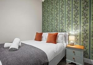 a bedroom with a bed and a table with a night stand at The Narrow House - Free Parking By My Getaways in Brighton & Hove