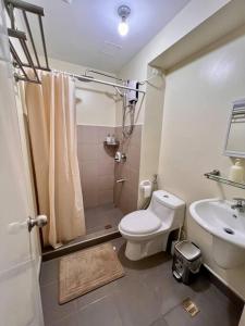 a bathroom with a shower and a toilet and a sink at Condo Unit near Ayala Serin Mall in Tagaytay