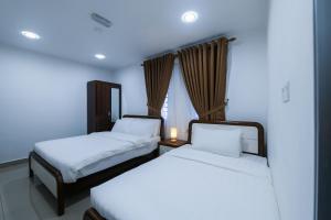 a bedroom with two beds and a window at SP Star Hotel in Sungai Petani