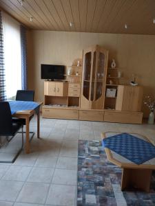 a living room with a table and a tv at Ferienwohnung Bruss in Saarlouis