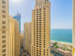 uitzicht op een stad met hoge gebouwen en de oceaan bij Luxury Waterfront Apartment with Beach Access in Dubai