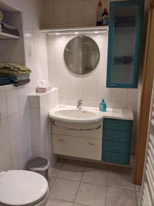 a bathroom with a sink and a toilet and a mirror at Ferienwohnung Bruss in Saarlouis