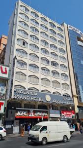 a white van parked in front of a large building at Phoenicia Grand Hotel in Dubai