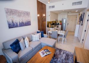 un soggiorno con divano e tavolo di Nasma Luxury Stays - Modern Apartment With Cityscape And Skyline Views a Dubai