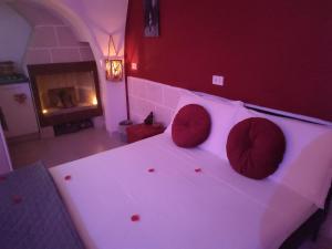 Un dormitorio con una cama blanca con paredes rojas y una chimenea en La Suite del Brigante, en Gioia del Colle
