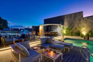 a rooftop patio with furniture and a swimming pool at The Almin Hotel in Ha Long