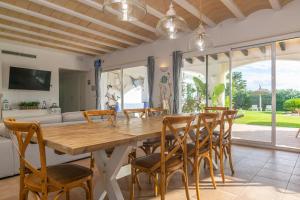 Villa Binimigi في Binisafua: غرفة طعام مع طاولة وكراسي خشبية