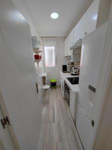 cocina con nevera blanca y suelo de madera en Apartamento Manuel Becerra en Madrid