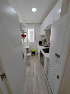 uma cozinha com um frigorífico branco e piso em madeira em Apartamento Manuel Becerra em Madrid