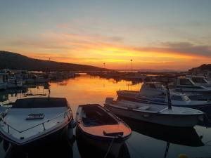 a group of boats docked in a harbor at sunset at Apartments by the Sea in Lopar