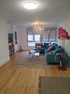 ein Wohnzimmer mit einem blauen Sofa und einem Tisch in der Unterkunft Céntrico y amplio piso con plaza parking in Cangas