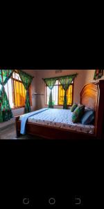 a bedroom with a large bed with windows at ZIMBE HOST Apartment in Arusha