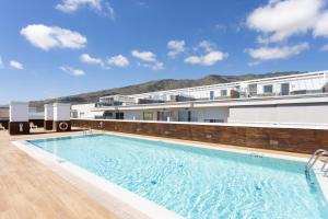 a large swimming pool in front of a building at River Suite El Galeón in Adeje