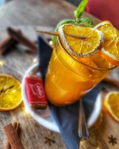 une boisson avec une tranche d'orange sur une table dans l'établissement Hotel Sportowy, à Wolsztyn