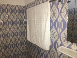 baño con lavabo y cortina de ducha en Residence MaryHouse en Cotonú