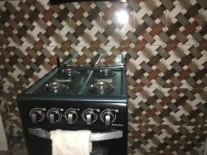 a black stove in a kitchen with a wall at Residence MaryHouse in Cotonou