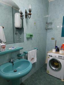 uma casa de banho com um lavatório e uma máquina de lavar roupa em 1 bedroom apartment in the heart of Cairo , just 15 minutes from the airport em Cairo