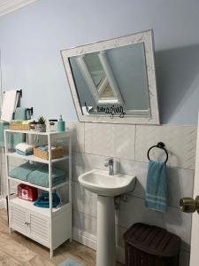 a bathroom with a sink and a mirror at Arcadia Studio Apartment in Augier