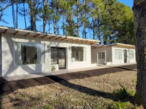 ein Haus mit einem Baum davor in der Unterkunft Los pinares in Santa Clara del Mar